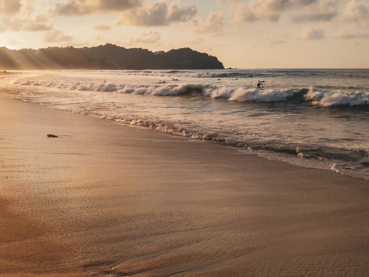 A surfer on a beach in Nayarit, Mexico