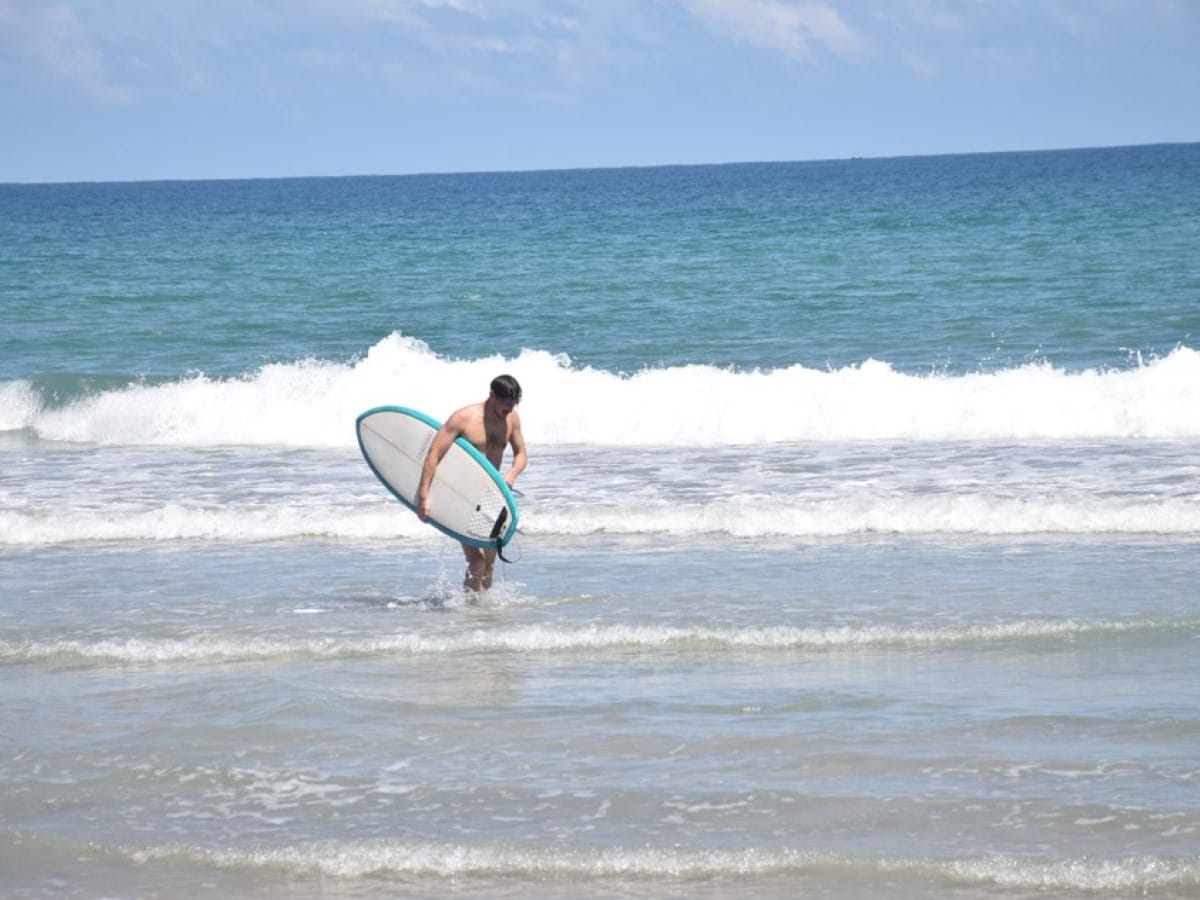 A surfer in clean blue water in Sri Lanka