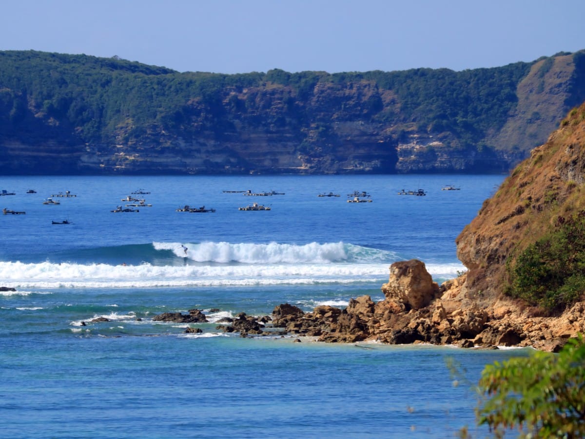 A surfer on a wave in Gerupuk