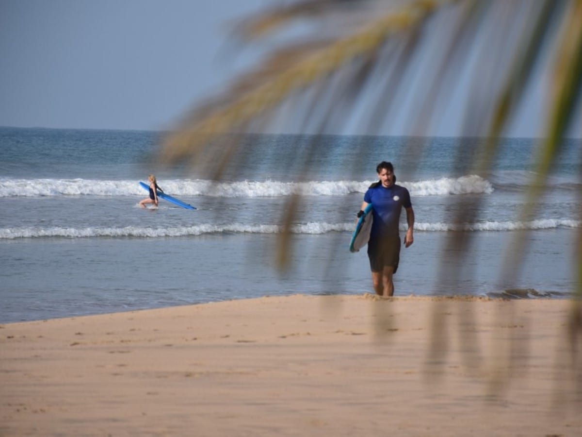 A surfer on a beach break in Sri Lanka